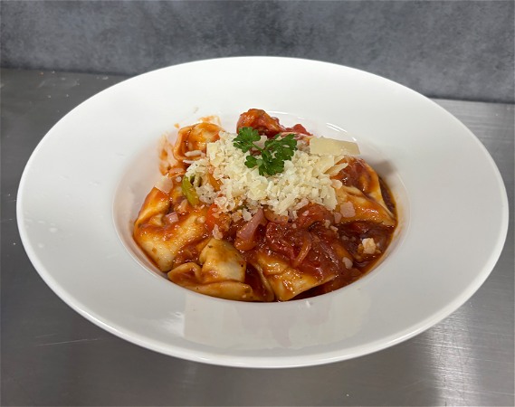 Tortelloni (gevuld met vlees) in tomatensaus met rode ui en paprika