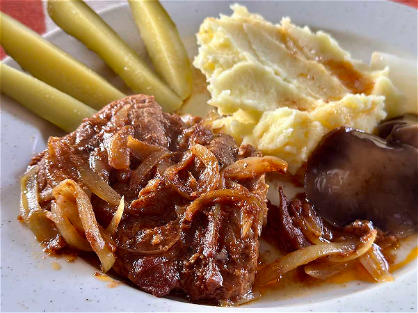 Stek z karkówki duszony z cebulą w sosie z pieczeni podana z ziemniakami i surówką 
