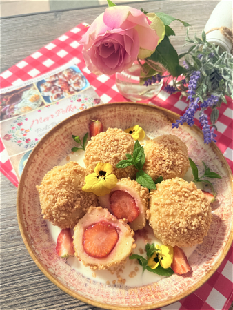 Kwarkknedels met aardbeien, geserveerd in een krokante notenkorst, en dat alles overgoten met vanillesaus 😍